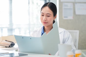 asian female doctor holding a medical file