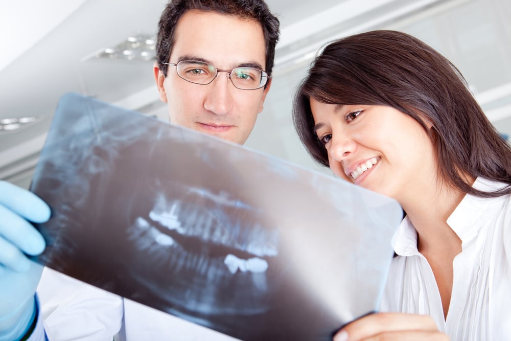 two dental professionals reviewing a patient x-ray