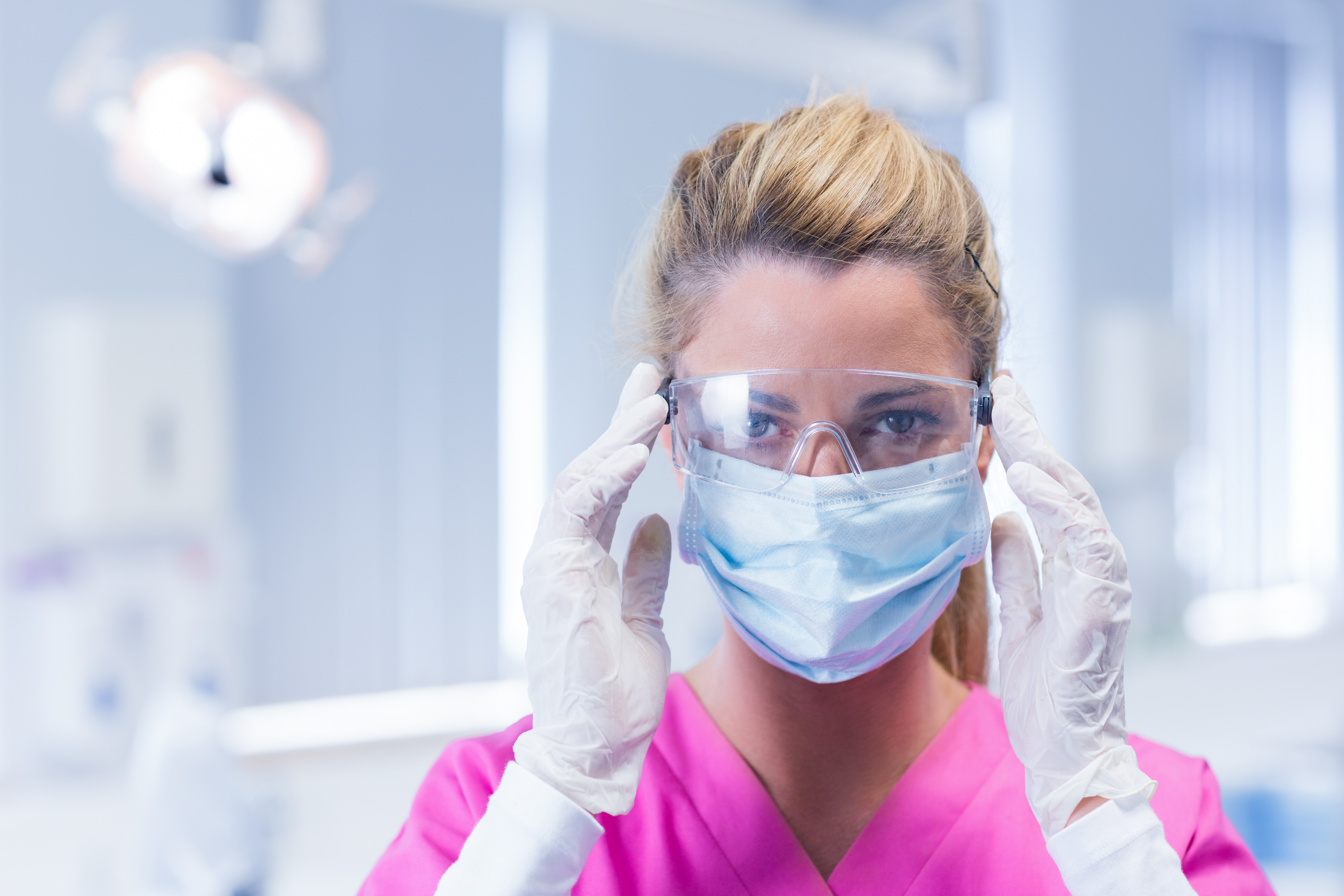 female dentist in eyewear and face mask
