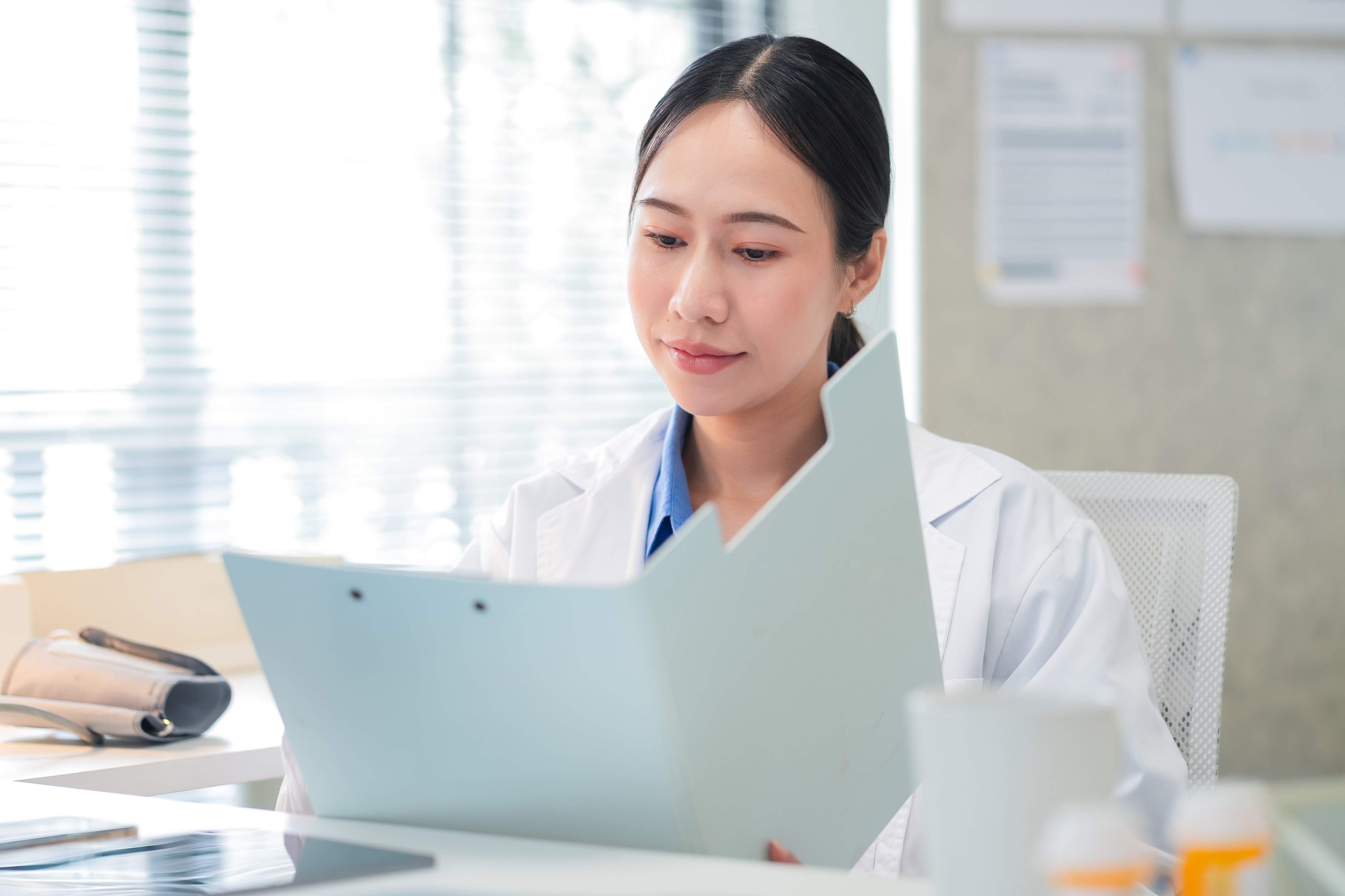 asian female doctor holding a medical file