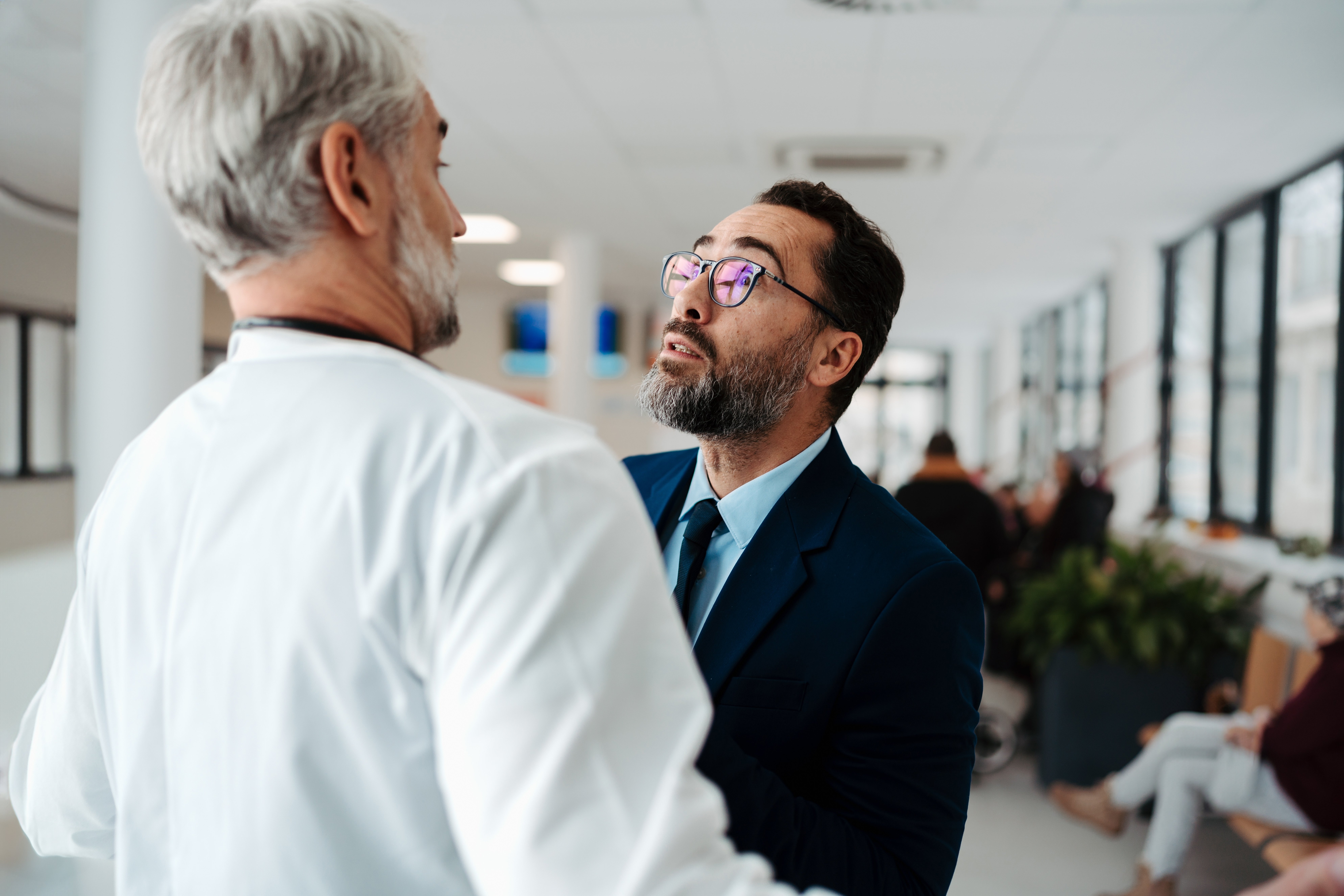 male patient in a suit threatening a doctor
