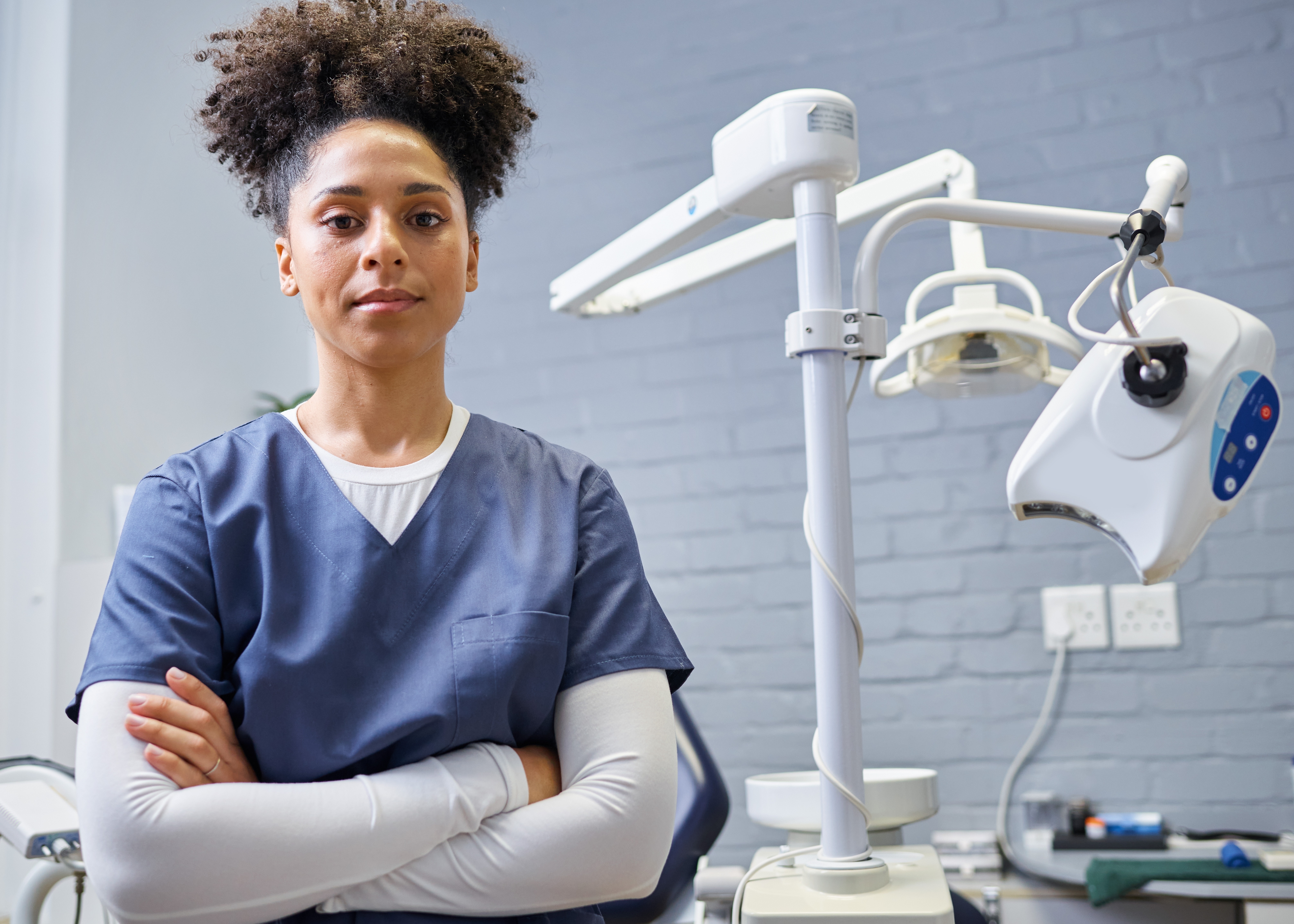 Dental professional standing in front of dental equipment