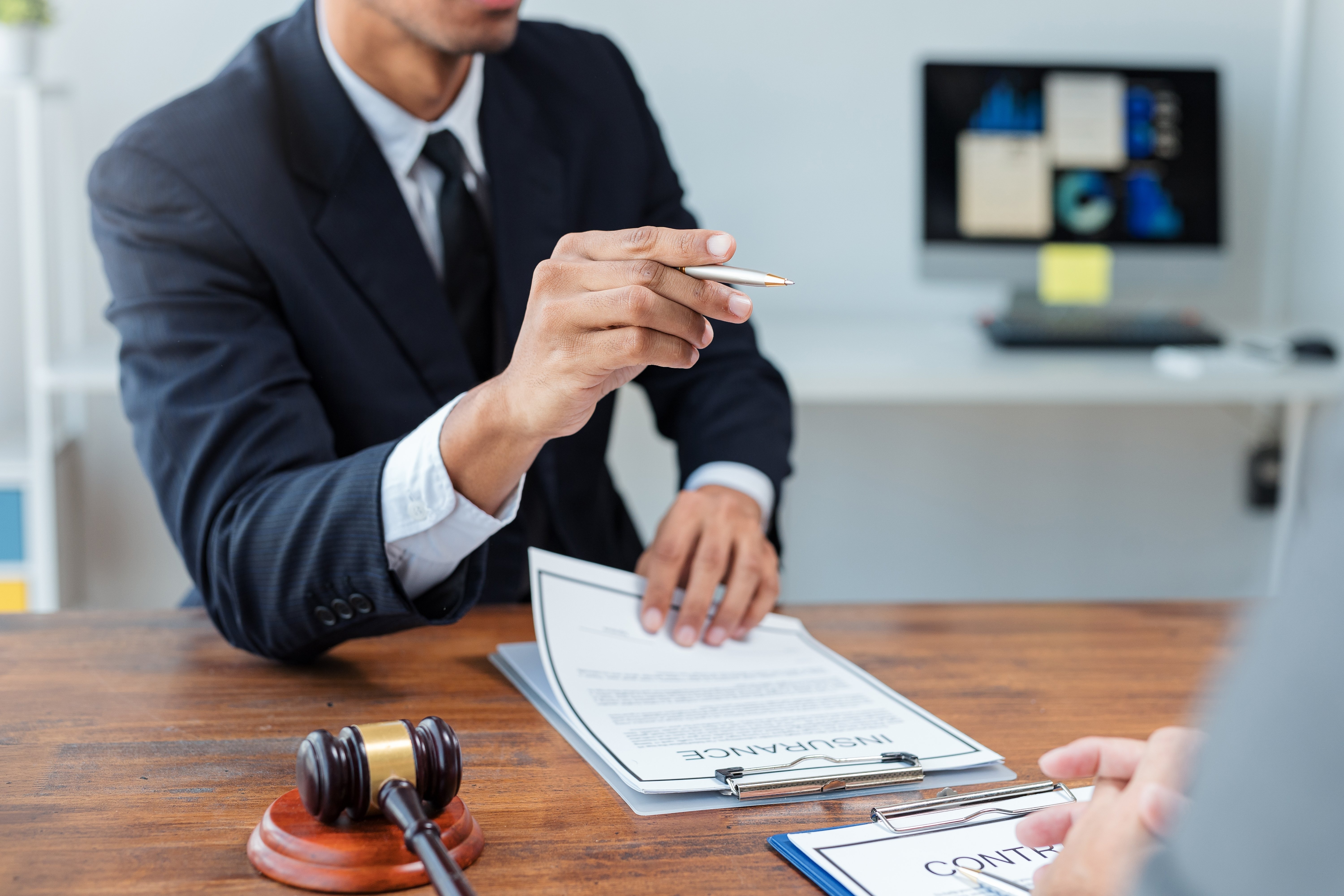 attorney holding a pen and pointing it with a gavel